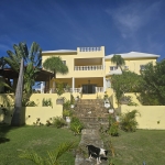 Fachada de casa en venta cerca de la playa con jardín y marquesina