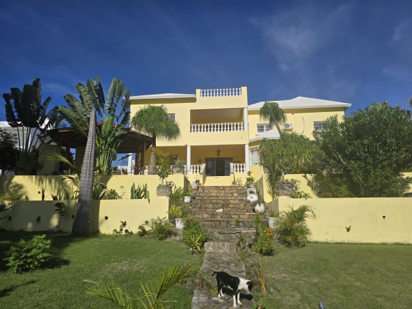 Fachada de casa en venta cerca de la playa con jardín y marquesina